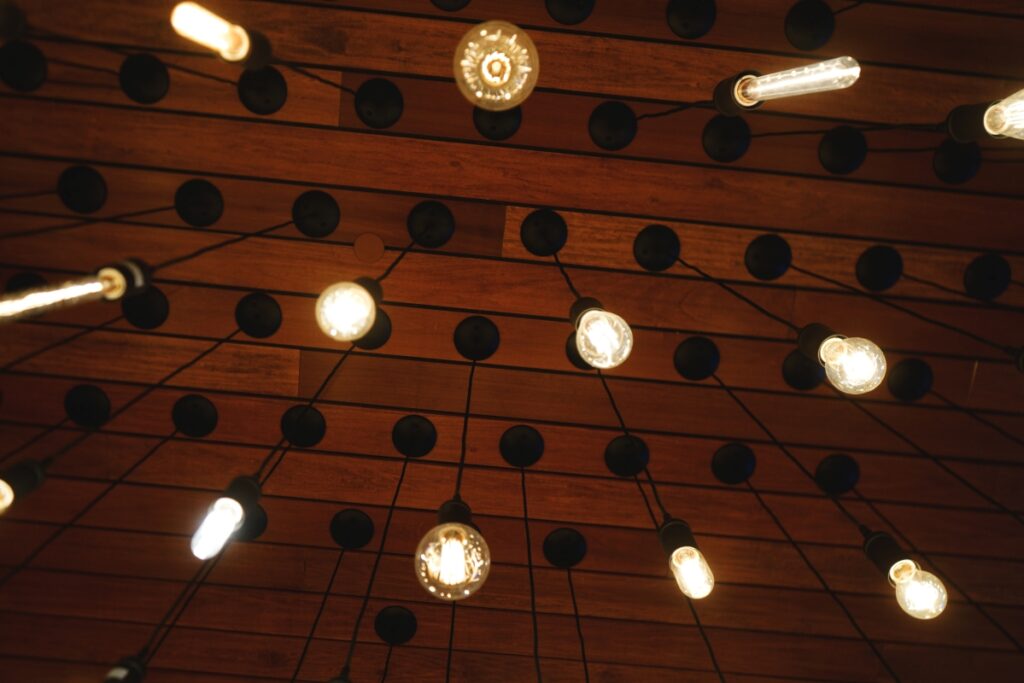 lit light bulbs hang from a ceiling at a bar mitzvah party
