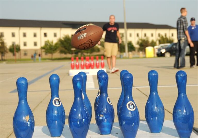 a football flying through the air towards blue bowling pins for children's party