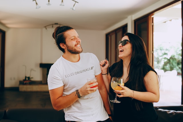 2 people laughing while attending a virtual cocktail party