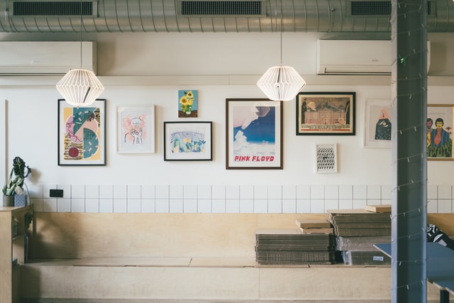 a white wall holds a group of various artwork - 4 ways to market your art