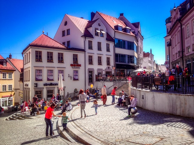 a number of families spend time on a sunny day in a small downtown