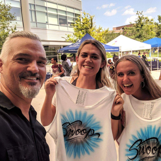 People showing off their airbrush shirts they got at a creative business meeting idea. 