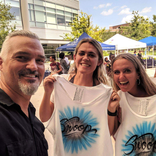 People showing off their airbrush shirts they got at a creative business meeting idea.