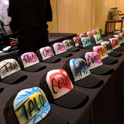 A display of airbrush hats at a corporate event. 
